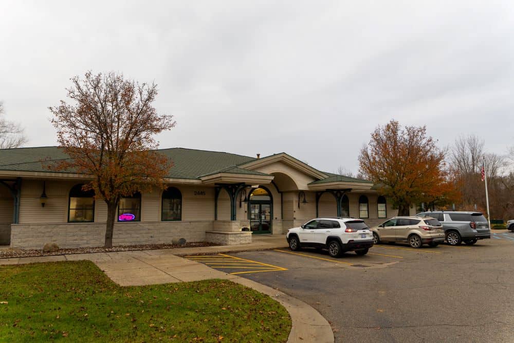 Front side of patmos library buillding with cars in parking lot